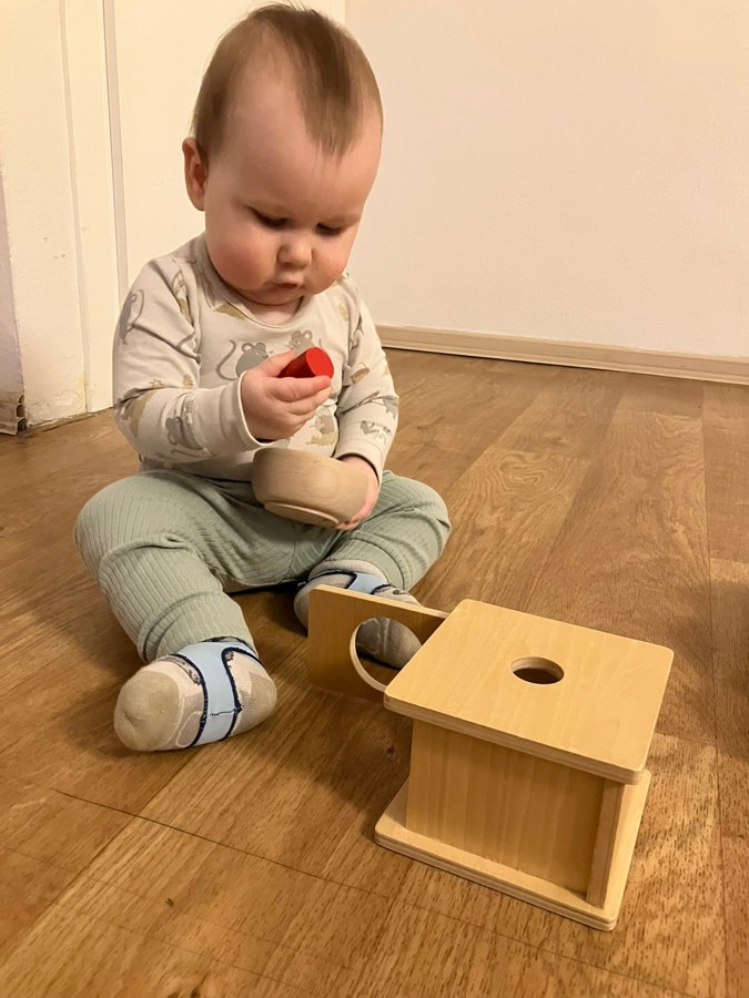 dieťa s Montessori pomôckou na podlahe